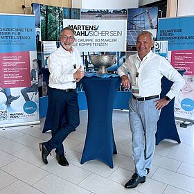 Markus Stegmann und Frank Ehrmann stehen an einem Tisch auf der Heuberg Forum Messe