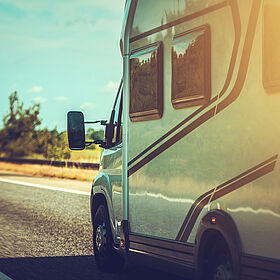 Wohnmobil auf Straße und die Sonne strahlt