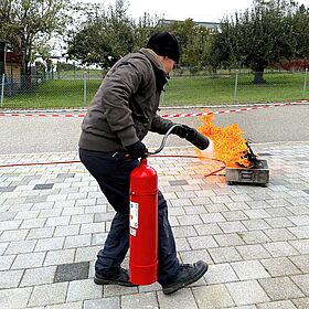 Demonstration Löschaktion Brandschutzhelfer mit einem Feuerlöscher