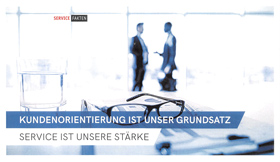 Zwei Mitarbeiter sprechen vor großer Fensterfront - "Kundenorientierung ist unser Grundsatz. Service ist unsere Stärke."